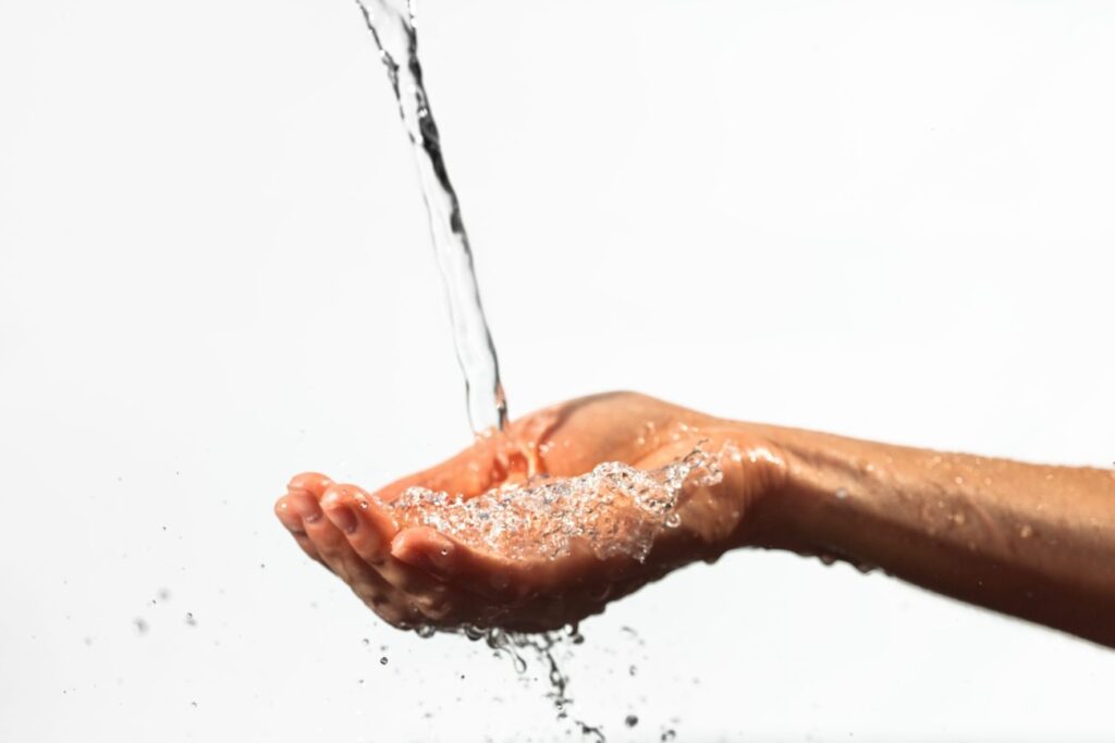 closeup-of-stream-of-water-flowing-on-palm-scaled-1.jpg