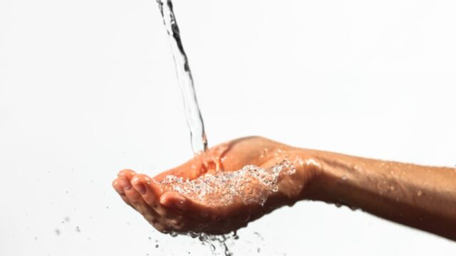 closeup-of-stream-of-water-flowing-on-palm-scaled-1.jpg
